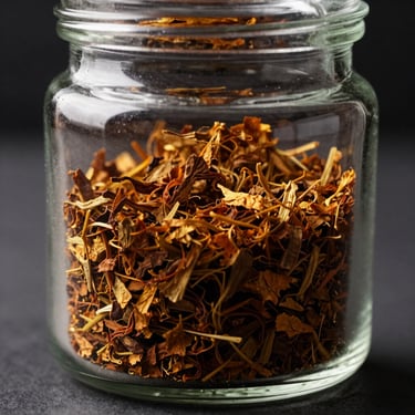 An elegant glass jar containing rich golden-brown tobacco flakes, illuminated by dramatic side-light, highlighting the coarse texture.