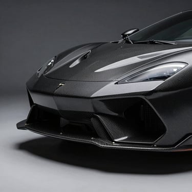 Close-up of a rare supercar rear diffuser showing exposed carbon fiber weave, sharp geometric lines, low-key dramatic studio lighting.
