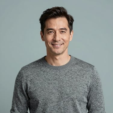A professional portrait of a man in his 40s with a kind expression. He is wearing a sophisticated grey sweater. Clean, high-end photography style with #3D5B5F accents.