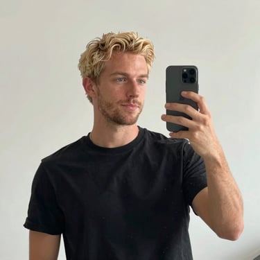 Smiling woman in workout clothes holding a smartphone showing the trêsviva ebook.