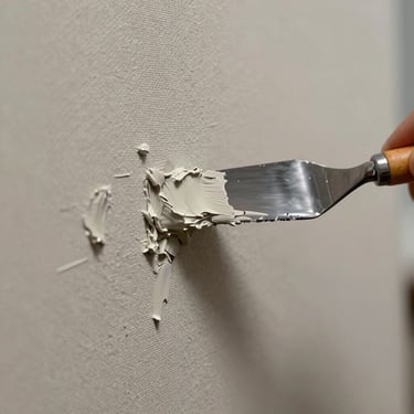 Extreme close-up of thick, textured oil paint being applied to a canvas with a palette knife, showing raw pigment details and natural gallery lighting.