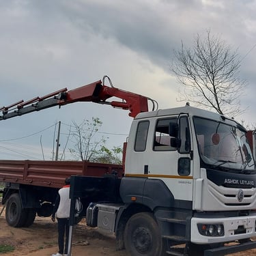 A parked truck with a crane attachment beside the road.