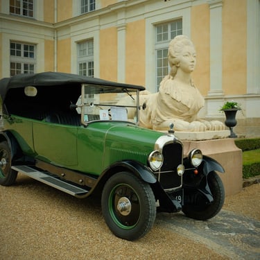 automobile de collection verte garée devant une statue
