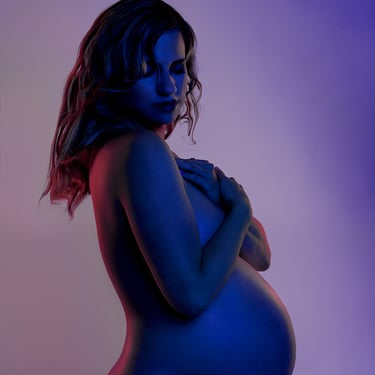 Femme enceinte de profil avec un éclairage rose et violet pour une photo sensuelle et glamour