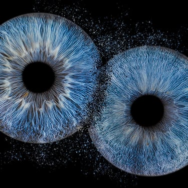 shooting de deux iris bleus avec un éclat particules et fusion entre eux