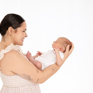 Photographie de nouveau-né dans les  bras en face du visage de sa maman pour plein de tendresse entre eux 