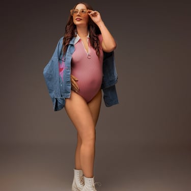 photographie de grossesse en mode style avec une veste en jean et un body rose
