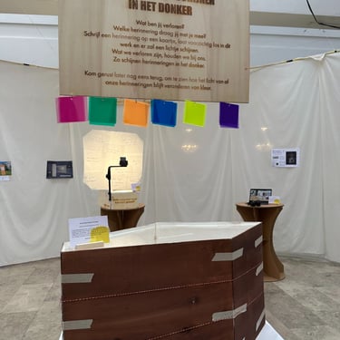 Herinneringen schijnen in het donker; een installatie die gekleurd licht schijnt op de ingeworpen kaartjes