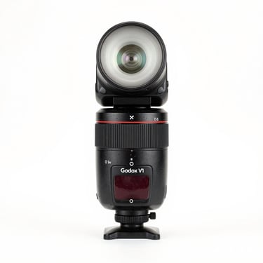 Godox V1 round head camera flash, speedlight, clean white studio backdrop, high-key lighting