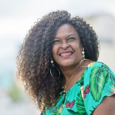 Patricia, Mulher negra sorrindo após emagrecer com a Dieta Inteligente, usando camiseta verde.