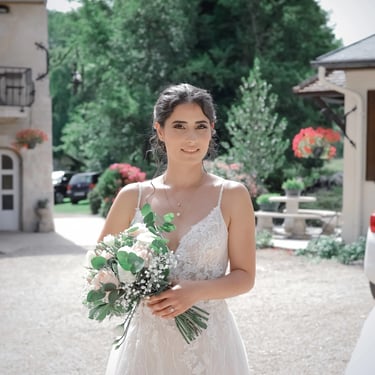 jeune mariée brune tenant un bouquet de fleurs