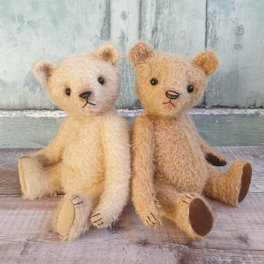 a pair of handmade teddy bears with threadbare noses and glass eyes