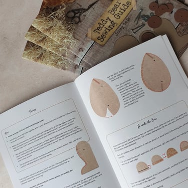 an illustrated teddy bear sewing guide open at a page showing how to make a teddy bear