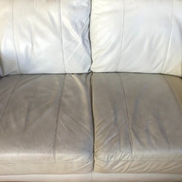 heavily soiled white leather 2-seater