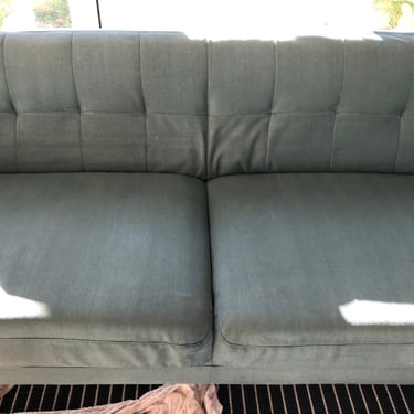 previously Heavy-soiled green 2-seater sofa now cleaned after professional mattress cleaning.