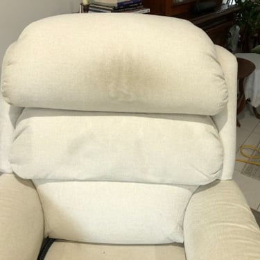 white recliner with dark spot on the headrest and armrests