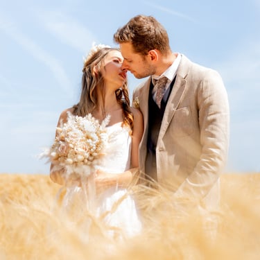 un couple de jeunes mariés qui s'embrassent dans les champs