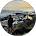 A person standing on rocky cliffs overlooking a scenic ocean coast at sunset.