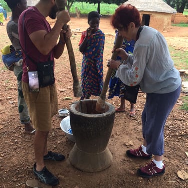Tourist pounding Local Cheese plants in Fulani Village in Benin during their Tour with Dahomey African Tours