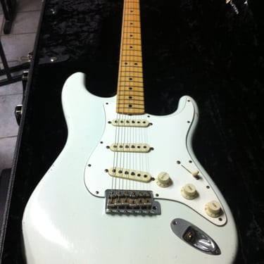 A sleek electric guitar with a richly patterned dark wood finish and detailed inlay work on the fret