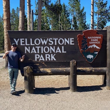 Ben Direen at Yellowstone National Park sign
