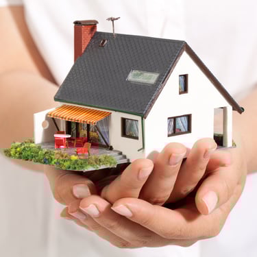 a person holding a miniature house in their hands