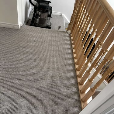 Grey Berber carpet installed in London hallway – textured and durable carpet for high-traffic areas.