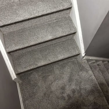 Grey carpet installed on stairs with landing in London – durable and soft carpet for busy households.