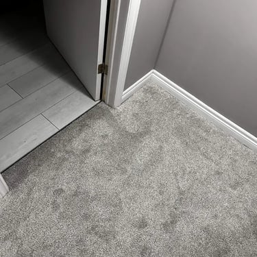 Grey plush carpet flooring installed in London basement – soft, comfortable carpet perfect for cozy spaces.