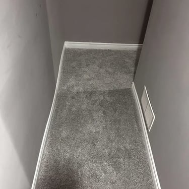 Grey plush carpet installed in a London basement – soft and durable carpet for cozy living spaces.