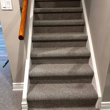 Close-up view of dark grey berber carpet installed wall-to-wall on residential stairs in Tillsonburg Ontario
