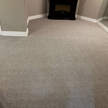 Basement with dark grey berber carpet installed wall-to-wall in residential home in Tillsonburg Ontario