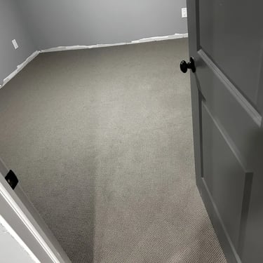 Basement with dark grey low pile berber carpet installed wall-to-wall in East London Ontario residential home
