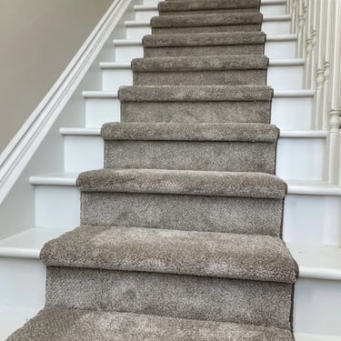Staircase with brown carpet runner installation in White Oaks home