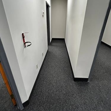 Office hallway with black commercial carpet installed wall-to-wall in London Ontario, durable flooring solution