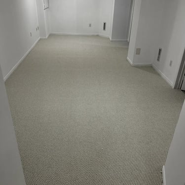 Basement living room with thick white berber carpet installed wall-to-wall in London Ontario home