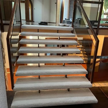 Unity65 carpet installed on Hollywood-style staircase, clean beige tone with smooth, low-pile texture wrapping each step