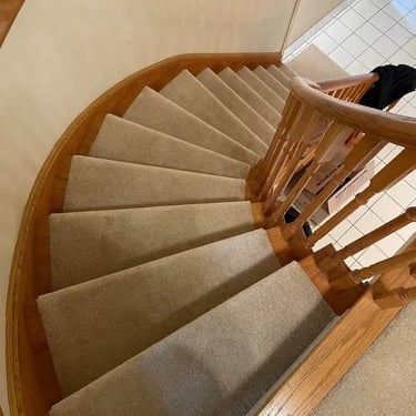 Beige plush carpet installed wall to wall on staircase, soft and cozy texture with smooth, seamless finish