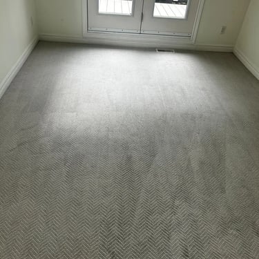 Bedroom carpeted with soft grey arrow-pattern plush carpet in White Oaks, London. Stylish wall-to-wall installation.