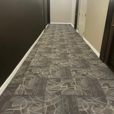 Commercial apartment hallway with durable grey carpet tile installation in London, Ontario. Long corridor view