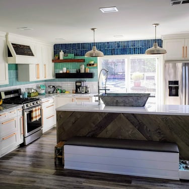 After picture of fully remodeled kitchen.  Custom cabinetry, custom counters, waterfall edge island, blue hombre wall tile.