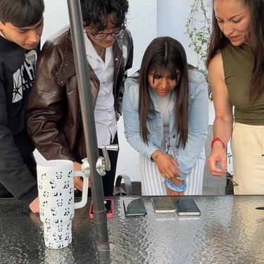 Grupo diverso de estudiantes de inglés haciendo una actividad digital en sus celulares.