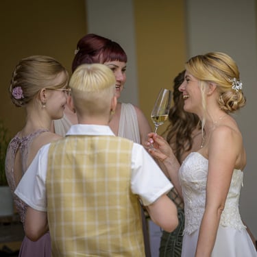 Emotionale Hochzeitsreportage: Braut stößt beim Sektempfang mit Familie und Gästen an.