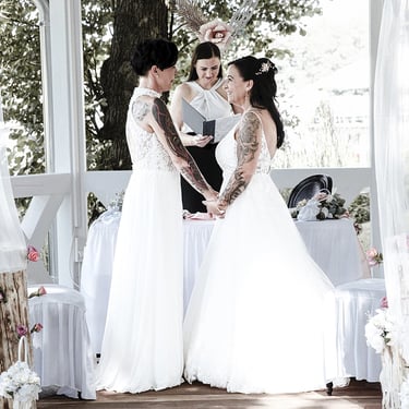 Freie Trauung eines gleichgeschlechtlichen Brautpaares in einem Pavillon während einer Hochzeitszeremonie