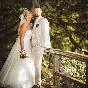 Brautpaar bei einem Hochzeitsshooting auf einer Holzbrücke im Park von Schloss & Gut Liebenberg