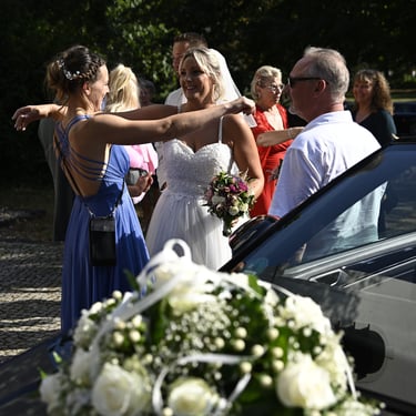 Braut wird nach der Trauung von Gästen im Freien beglückwünscht
