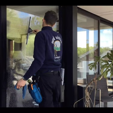 un laveur de vitres nettoie une véranda chez un particulier à Valenciennes