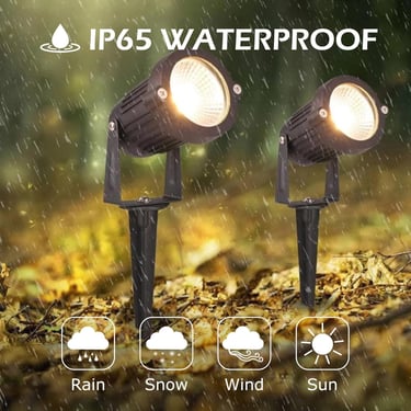 Two IP65 waterproof outdoor LED spotlights with ground stakes illuminating a garden in the rain.