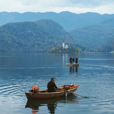 Putnici veslaju u čovnu na Bledskom jezeru u Sloveniji.