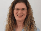 a woman with long hair and glasses on her face